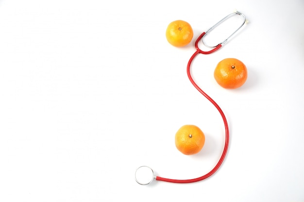 Fruits orange avec stéthoscope rouge sur blanc