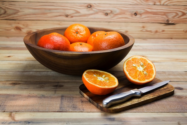 Fruits orange sur une table en bois avec un couteau