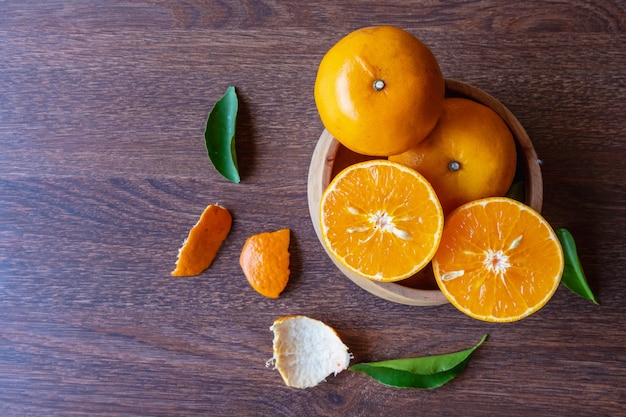 Fruits oranges frais sur un bol en bois