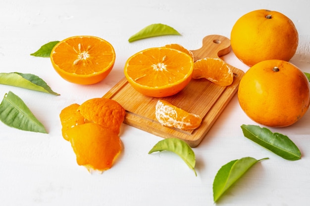 Fruits oranges frais coupés en deux sur fond de bois blanc