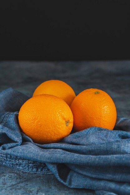 Fruits oranges près du textile denim sur tableau noir Concept minimal d'agrumes de fruits juteux orange