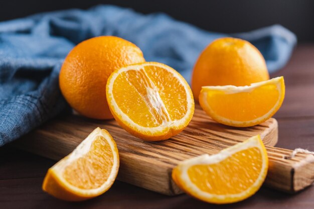 Fruits oranges tranchés près de textile denim sur planche de bois Concept minimal d'agrumes de fruits juteux orange