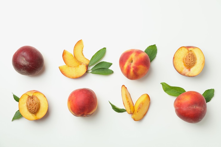 Photo fruits de pêche mûrs avec des feuilles sur fond blanc