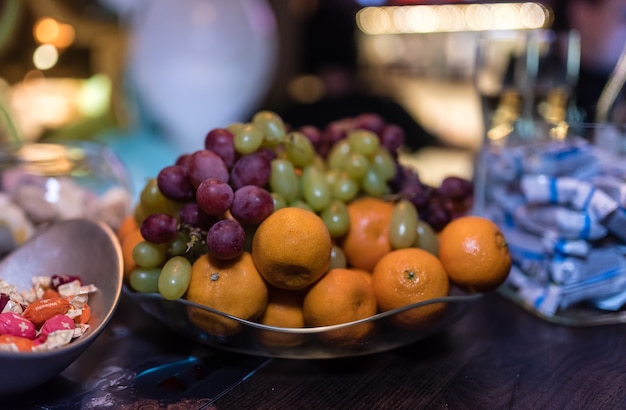 Fruits sur un plateau à côté des bonbons