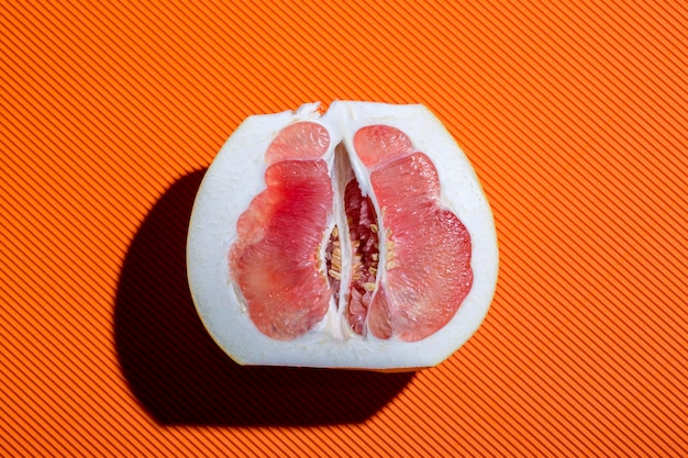 Fruits de pomelo tranchés sur un gros plan de fond orange