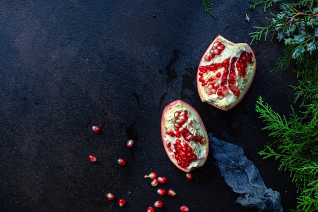 fruits rouges grenade sur la table et branches de sapin