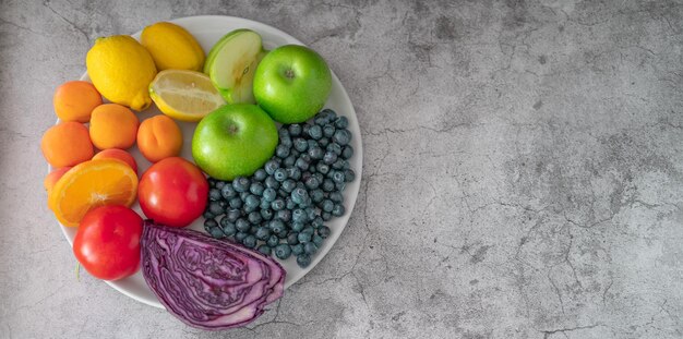 fruits sains et nutritifs de couleurs commandés dans une assiette sur fond de pierre