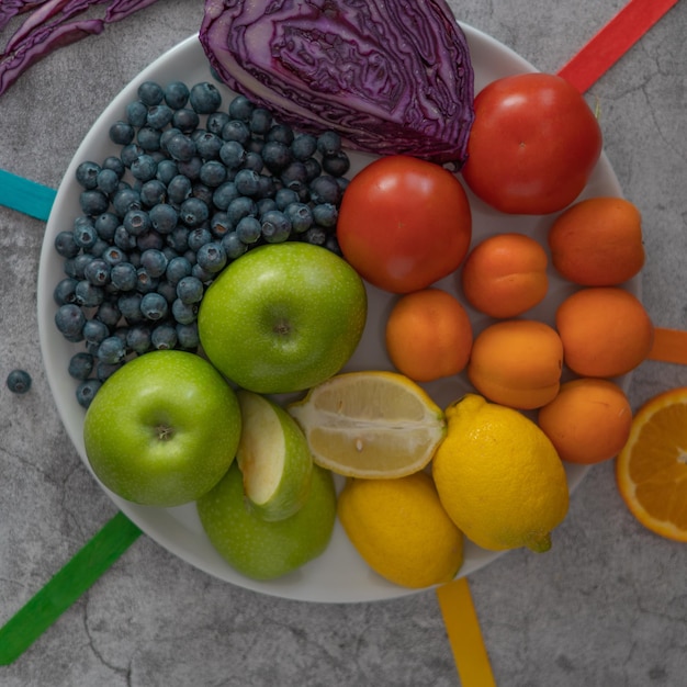 fruits sains et nutritifs de couleurs dans une assiette sur fond de pierre