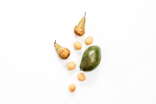 Fruits de saison: mangue, poires, abricots sur surface blanche