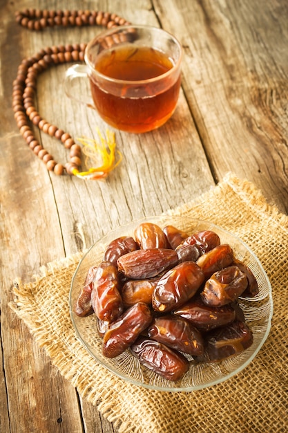 Fruits séchés date sur la plaque de verre sur la table en bois