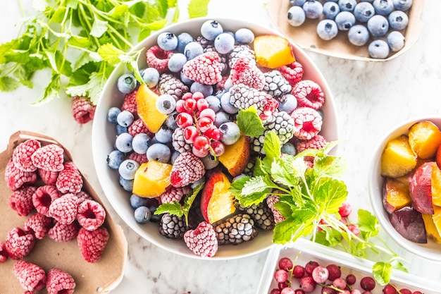 Fruits surgelés myrtilles mûre framboise groseille pêche et herbes mélisse.