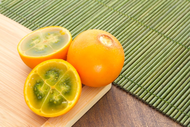 Fruits et tranches de lulo ou naranjilla sur la table en bois Solanum quitoense