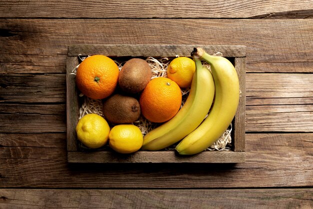 Fruits tropicaux frais dans une boîte en bois sur un fond en bois