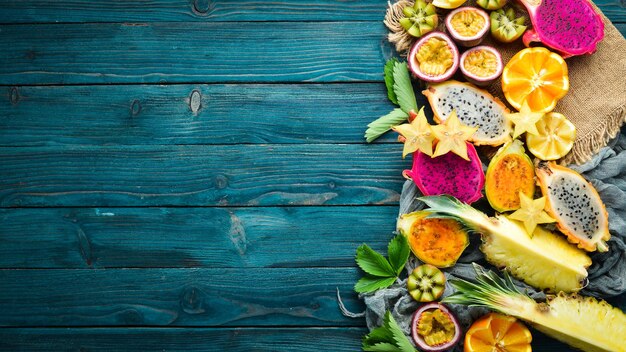 Fruits tropicaux - fruit de la passion, ananas, fruit du dragon, kiwi et cactus sur fond bleu.