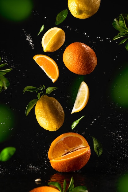 Photo fruits volants sur fond noir couverture publicitaire agrumes en gouttes d'eau