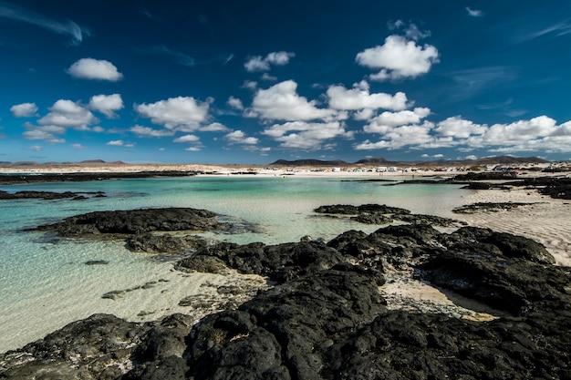 Photo fuerteventura avec pierres volcaniques et sable blanc caleta del marrajo îles canaries