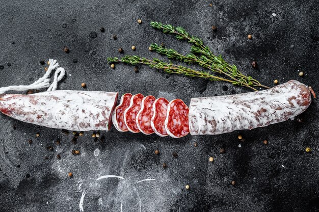 Fuet Salami coupé en tranches et romarin. Saucisse espagnole traditionnelle. Vue de dessus