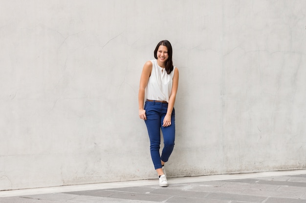 Full Body Shot of Brunette Belle jeune femme debout contre le mur à l'extérieur