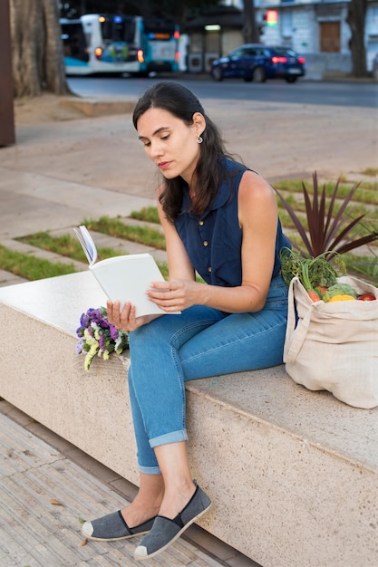 Full shot femme lisant à l'extérieur