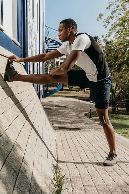 Full shot homme qui s'étend de la jambe