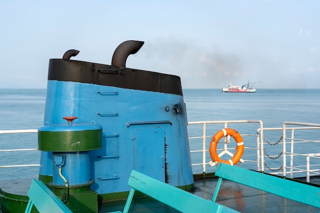 Fumée de la cheminée du ferry pendant la mer avec la lumière du soleil, l'eau de mer et le ciel bleu en arrière-plan, Thaïlande. A bord, cheminée d'un ferry ou d'un bateau de croisière, la cheminée pollue l'atmosphère