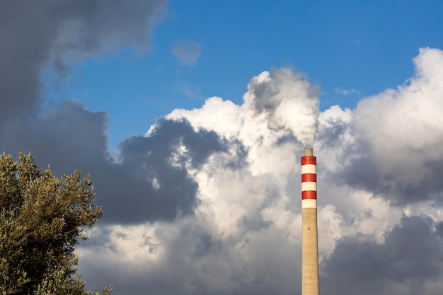 Fumée de cheminée d'usine avec ciel bleu et nuages