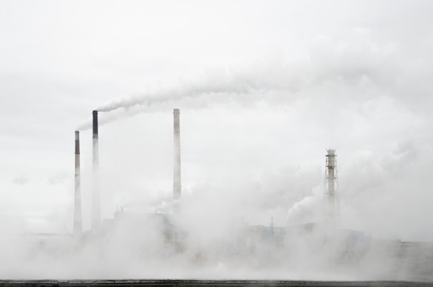 La fumée des cheminées d'une usine métallurgique s'élève dans le ciel. Tout est en fumée. Empreinte carbone