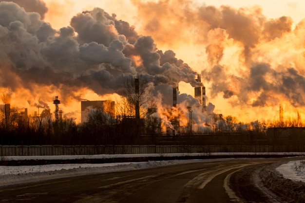 La fumée émise par l'usine contre le ciel en hiver