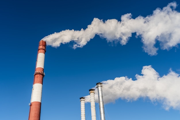 Fumée industrielle de cheminée sur ciel bleu