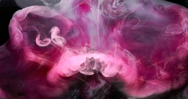 Fumée rose sur fond d'encre noire brouillard coloré abstrait tourbillonnant toucher océan mer peinture acrylique pigment sous l'eau