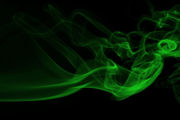 Fumée verte sur le concept de fond noir et l&#39;obscurité