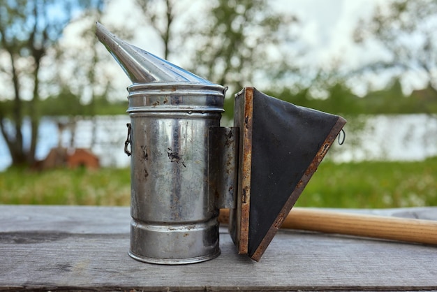 Fumeur d'abeilles sur le dessus d'une ruche d'abeilles un matin d'été fumer Un équipement de base de l'apiculture Concept d'apiculture