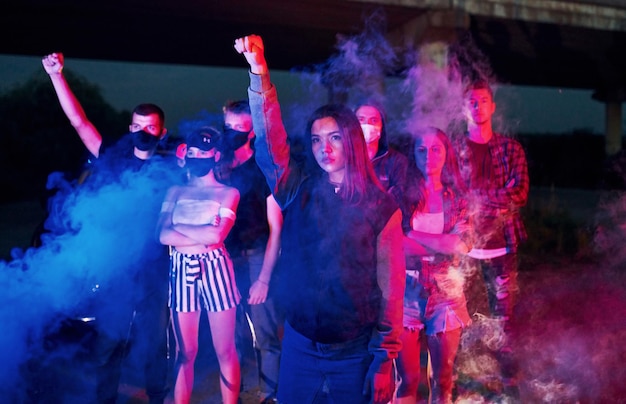 Fumez les poings de la police Groupe de jeunes protestataires qui se tiennent ensemble Militant pour les droits de l'homme ou contre le gouvernement