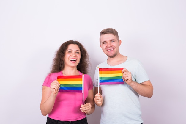 Fun homme et femme debout avec des drapeaux arc-en-ciel, concept lgbt