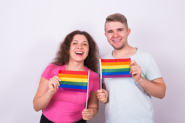 Fun homme et femme debout avec des drapeaux arc-en-ciel