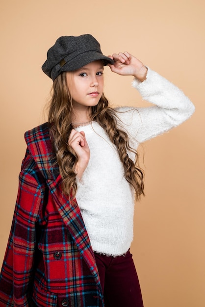 Photo funky beauté enfance heureuse beauté et mode joyeux enfant parisien a une longue coiffure élégant enfant porter une casquette française à la mode saisonnière automne mode look adolescente en veste à carreaux