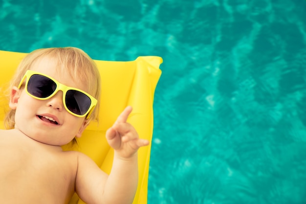 Funny baby boy en vacances d'été Kid s'amusant dans la piscine