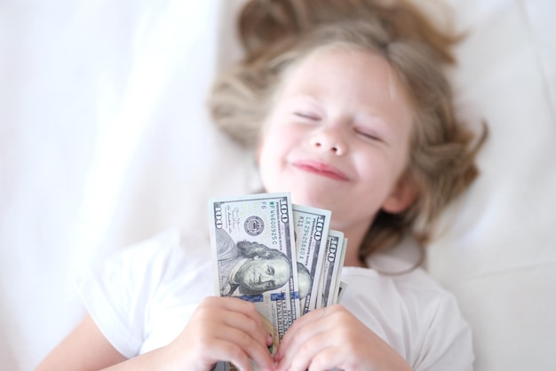 Funny baby girl tient des dollars et dort