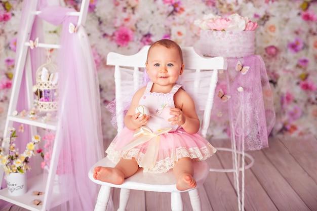 Photo funny baby girl toddler posant en jupe tutu sur décoration florale en studio