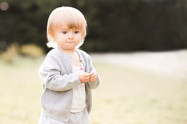 Funny baby girl walking in park en plein air