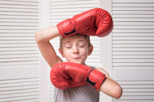 Funny boy en gants de boxe rouges. Concept sportif