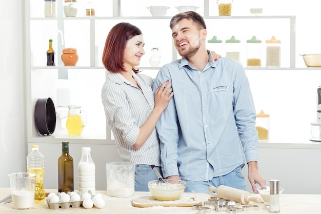 Funny Couple amoureux de la cuisson de la pâte et s'amuser avec de la farine dans la cuisine