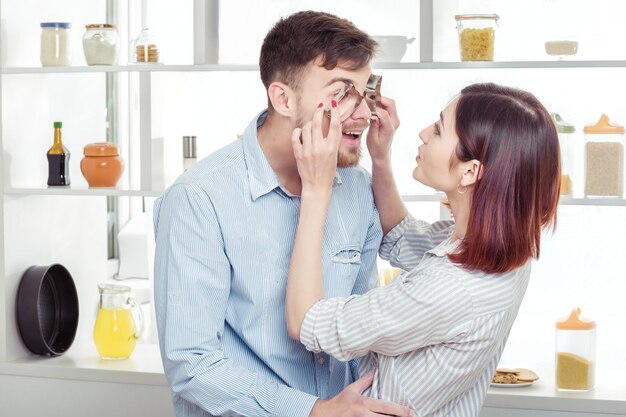 Funny Couple amoureux de la cuisson de la pâte et s'amuser avec de la farine dans la cuisine