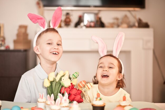 Funny girl and boy enfant portant des oreilles de lapin au printemps à la maison
