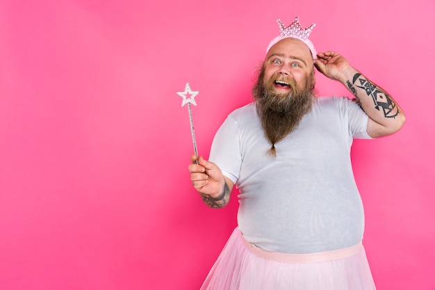 Funny gros homme faisant semblant d'être une ballerine avec tutu sur un mur rose