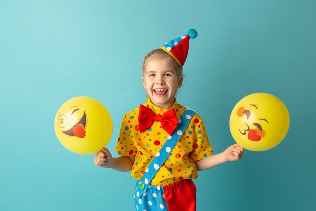 Funny kid clown sur fond bleu Anniversaire et concept du 1er poisson d'avril