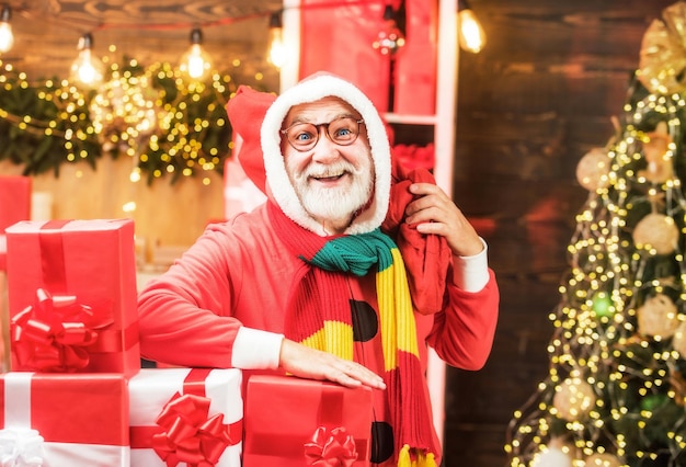 Funny santa hold cadeau de noël santa vieil homme posant sur fond de bois vintage thème noël ho