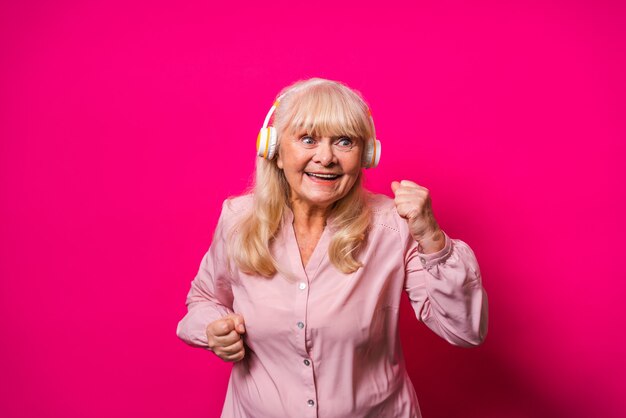 Funny senior woman écouter de la musique avec des écouteurs