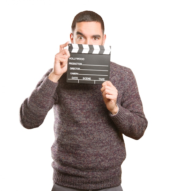 Funny young man using a clapperboard