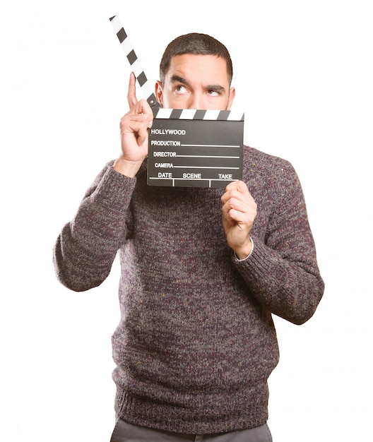 Funny young man using a clapperboard